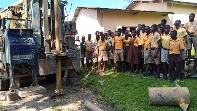 Einige Schüler sind gekommen, um den Brunnebau zu beobachten.